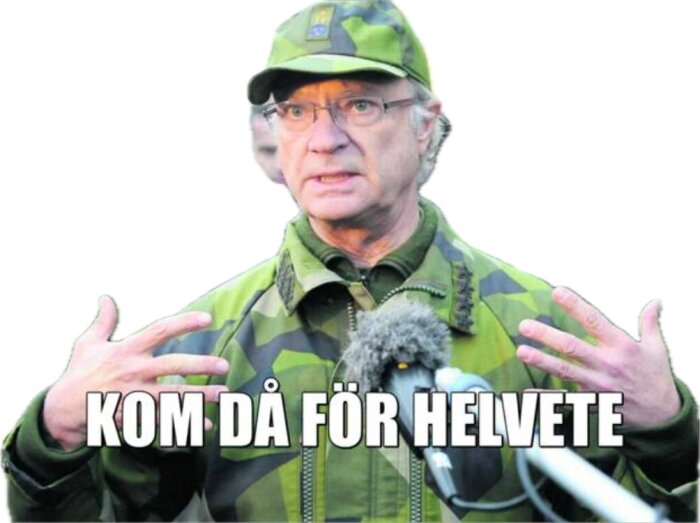 Man i kamouflagekläder och keps gestikulerar, mikrofon, text "KOM DÅ FÖR HELVETE".