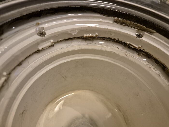 Närbild på smutsig tvättmaskintätning med mögel och smutsavlagringar. Behöver rengöring.