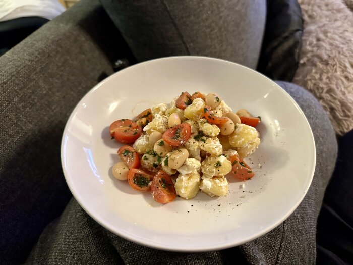 En tallrik med sallad bestående av tomater, bönor, ost och persilja. Enkel, fräsch, hemlagad mat.