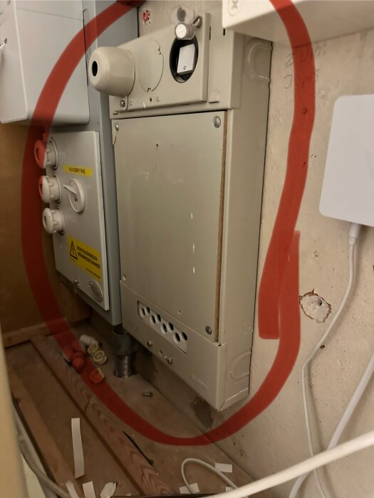 Gasvärmare installerad inne, rör och kablar synliga, underhåll eller installation pågår, verktyg och delar på golvet.