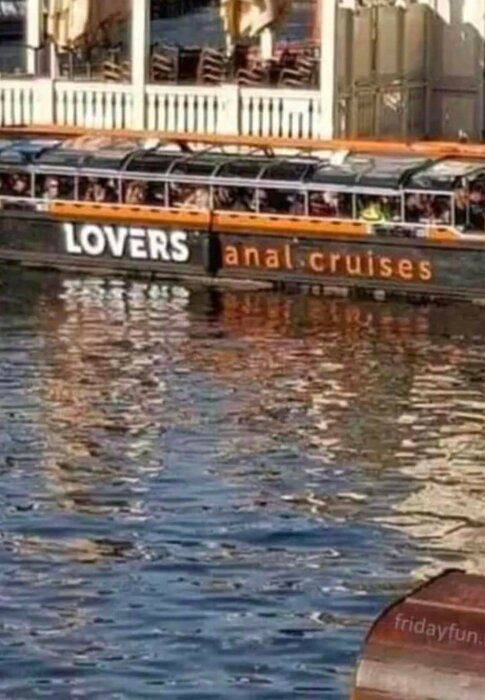Båt med texten "LOVERS canal cruises" där bokstäverna delvis är täckta så det ser ut som "anal cruises".