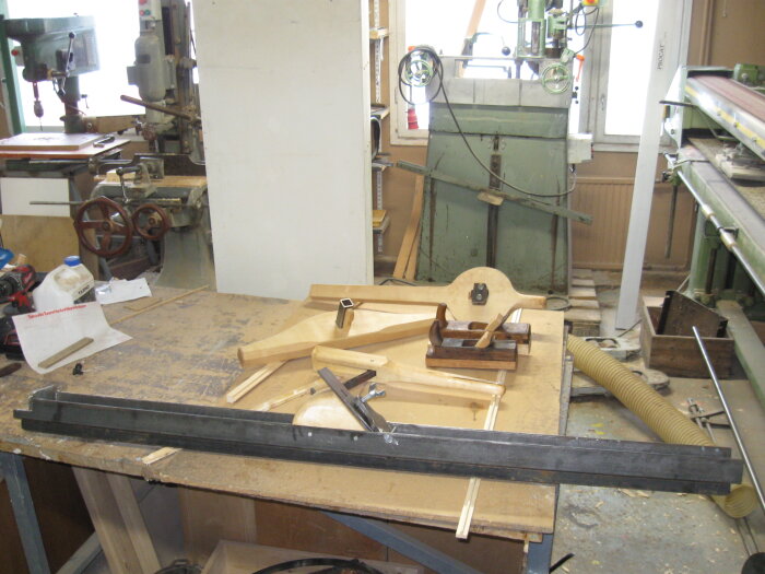 Hantverksverktyg på arbetsbänk i en verkstad, inklusive laggstråk, tjimbhyvlar, bandhaka och stråkbänk.