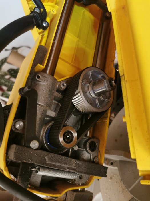 Närbild på motorcykelns kamrem och kamaxel i en öppen motor.