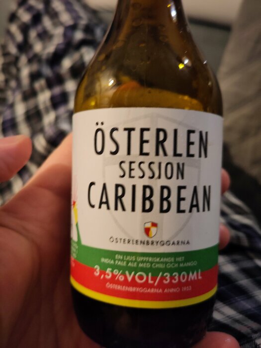 Flaska med Österlen Session Caribbean öl med etikett som visar chilipeppar och mango, 3,5% volym.