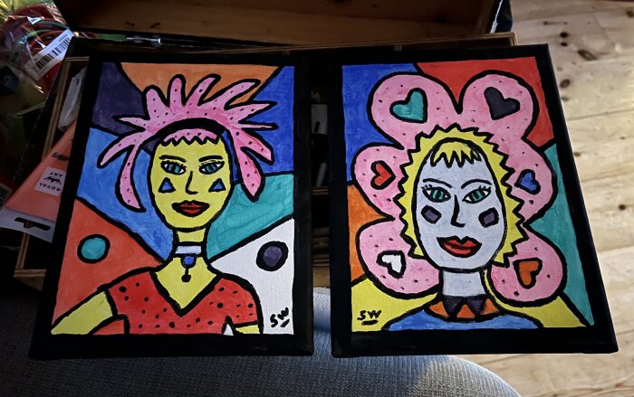 Två färgglada abstrakta porträttmålningar av kvinnliga figurer med unika frisyrer och smycken.