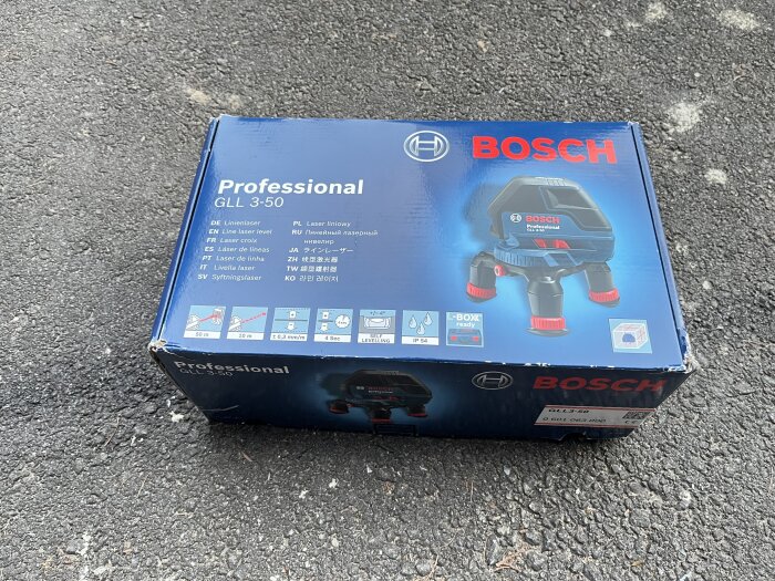 Oanvänd Bosch Professional GLL 3-50 korslaser i förpackning på asfalt.