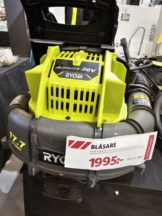 Ryobi blåsare, 1995 kronor, 36V batteri, prisinformation, affärsmiljö, produktmarknadsföring, grön och svart.