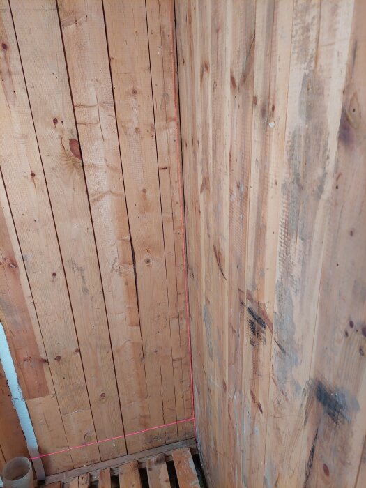 Rivna väggar i badrum med synlig lutning markerad av lasernivå.