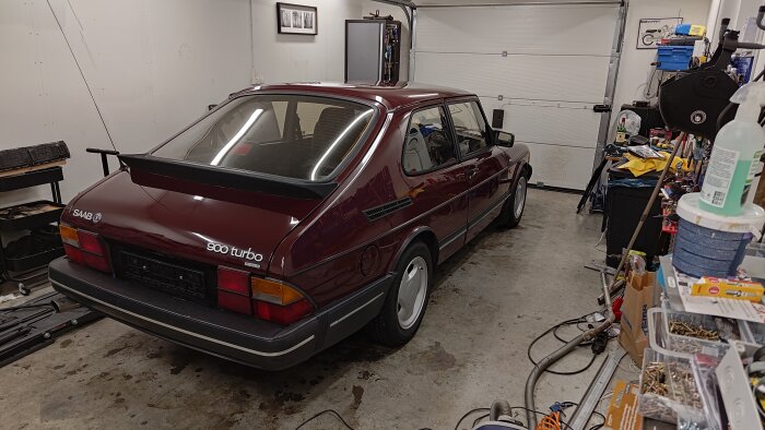 Röd Saab 900 Turbo efter polering i ett garage, glänsande lack och ren omgivning.