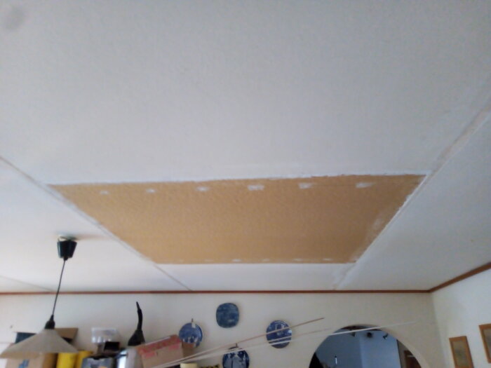 Ett innertak under reparation eller renovering med synlig spackel och ommålad yta.