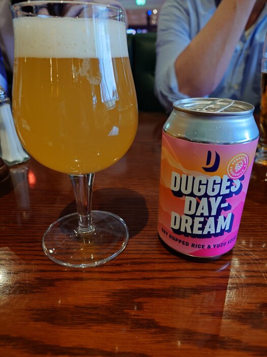 Ölglas med skum på en bar, bredvid en burk "Dugges Day Dream".