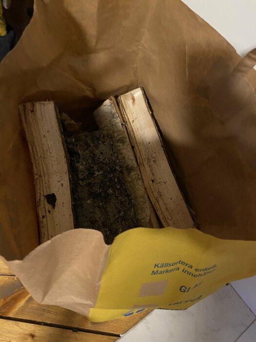 Papperskasse från Lidl fylld med brännved för uppvärmning.