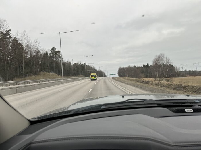 Bild från förarsätet som visar en gul bil 20 km/h under hastighetsgränsen på en motorväg, andra bilar kör om.