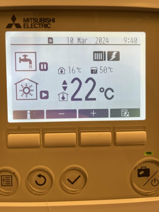 En Mitsubishi Electric termostat som visar temperatur, fuktighet, och andra inställningar. Datum och tid är synliga.