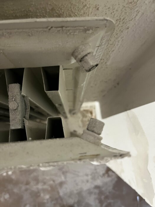 Bild på en dammig struktur, möjligen en del av ventilationssystem, sett underifrån.