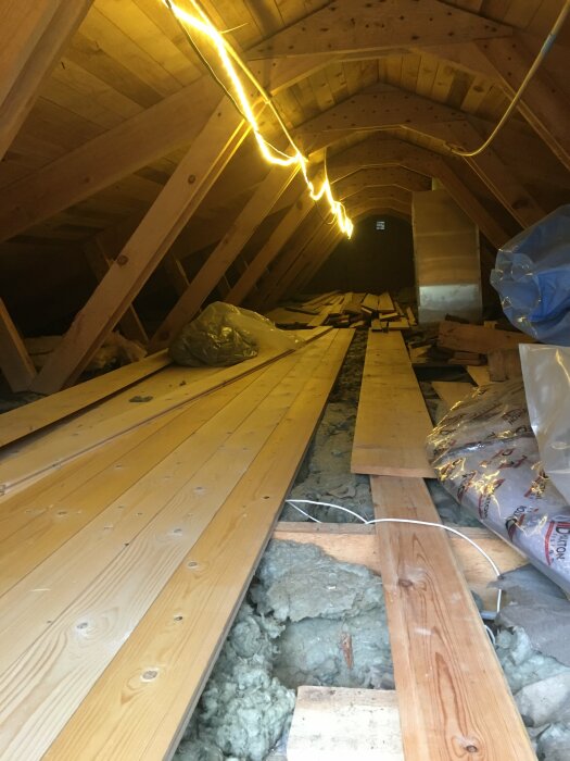 Oisolerat vindutrymme under renovering med träreglar och isoleringsmaterial synligt.