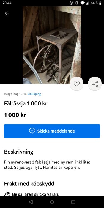 Nyrenoverad fältsåg av äldre modell med handvev och ny rem placerad i ett träskjul.