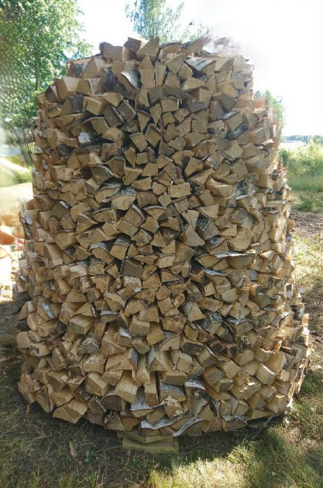 Sex-åttakantig vedstapel med lutning inåt placerad utomhus.