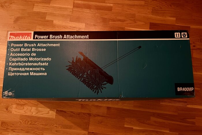 Makita Power Brush Attachment förpackning på trägolv.