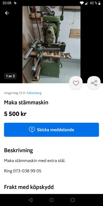 Grön äldre modell av stämknivsmaskin monterad på en träplatta i en verkstad.