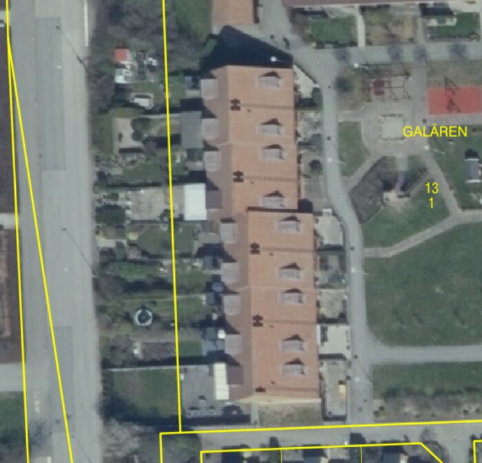 Satellitbild över en bebyggelse med en stor orange byggnad intill en gata, markerad för detaljplaneändring.