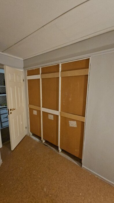 Renoveringsprojekt av ett sovrum med en omvänd garderob av trä som utgör vägg.