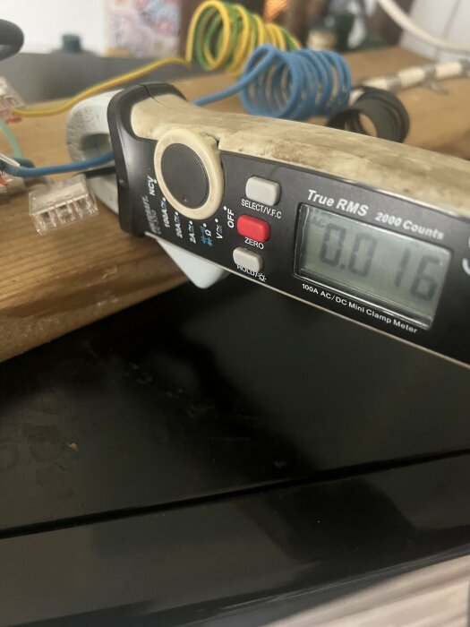 Multimeter som visar 0.16 ampere på en elektrisk ledning, används i felsökning.