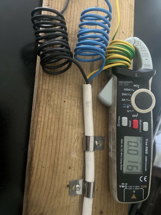 Elektrisk mätutrustning som visar 0.16 används för att mäta läckström på kablar och ett rör.