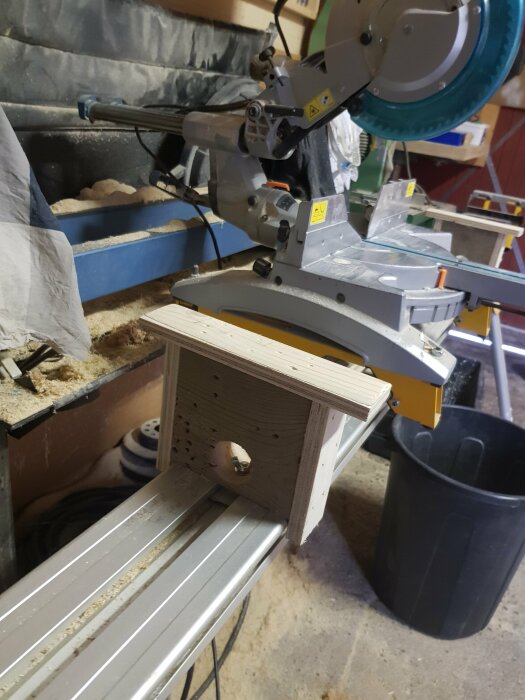 Hemmagjort stöd tillverkat av spillbitar monterat på ett sågbord i en verkstad.