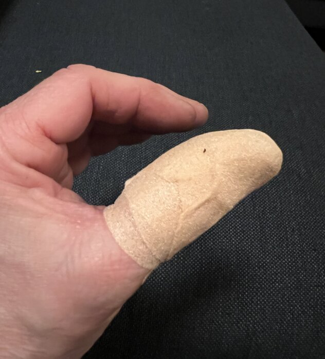 Finger med plåster efter en olycka med sågklinga, synligt skadat fingeravtryck.