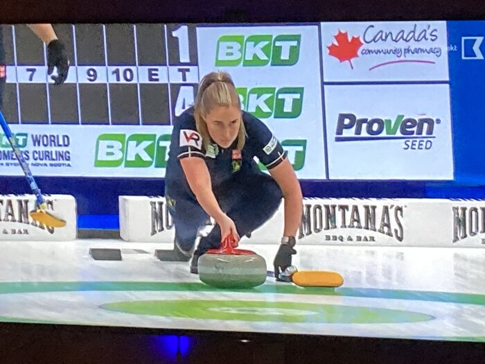 Curlingspelare förbereder sig att skicka en sten under en match i världsmästerskapet.