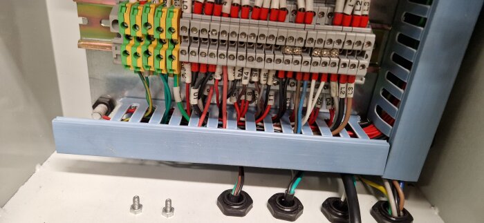 Elektrisk skåp öppnat med synliga säkringar, kablar och kabelskor, modifiering med kabel genomförd.