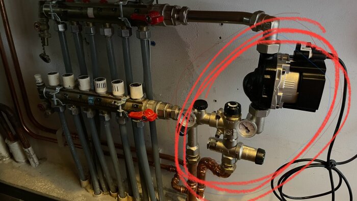 Installation av golvvärme med shunt och rör, ny shuntdel inringad med röd penna för att markera tillägget.