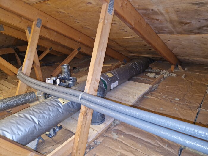 Vind med draget spiro-rör och ventilationselement, samt en brygga byggd av träplankor.