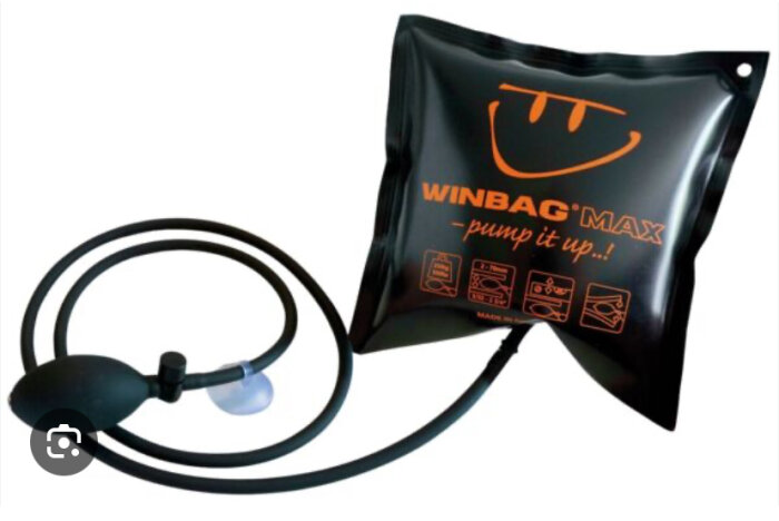 En svart uppblåsbar lyftkudde med slang och handpump märkt "WINBAG MAX - pump it up!" mot vit bakgrund.