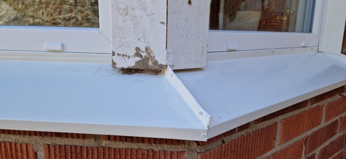 Nyinstallerat fönsterbleck med synliga tecken på dåligt hantverk vid husvägg och fönsterpost.