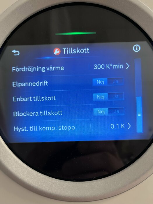 Digital display av en värmepump med menyn för Tillskott och inställningar för fördröjning värme och elpannedrift.