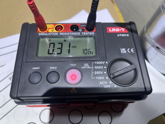 Isolationsresistansmätare som visar 0.31 MΩ vid en spänning på 106V under elektrisk testning.