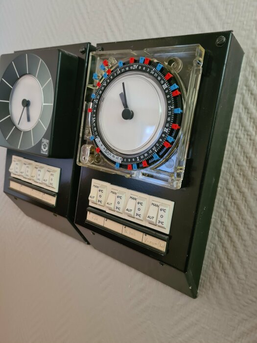 Analog timer för programmering av el med etiketterade knappar för olika rum.