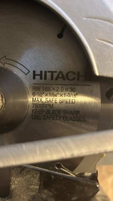 Närbild av en Hitachi cirkelsågsklinga med tekniska specifikationer synliga, använd för att kapa dörrar.