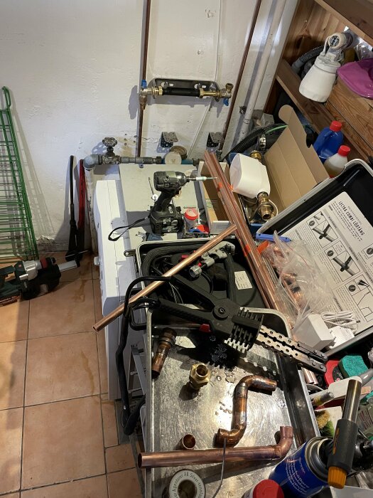 Installation av kopparledningar och vattenmätare med verktyg på en verktygsvagn i ett källarutrymme.