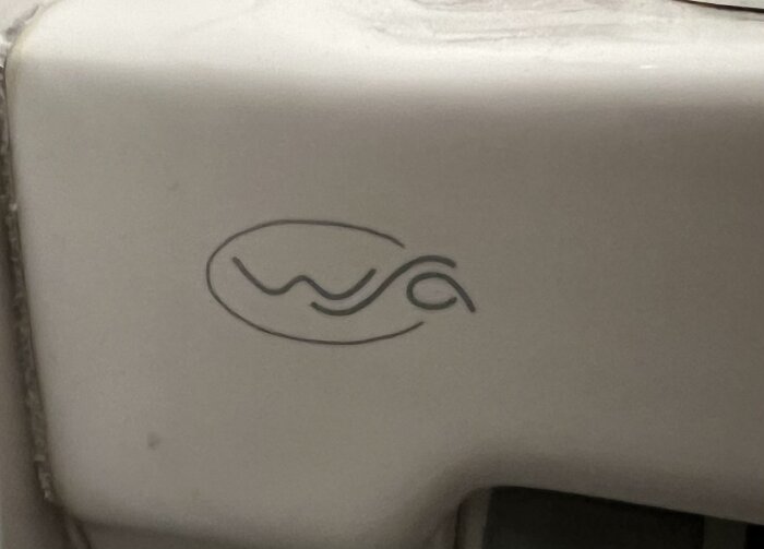 Närkru av en toalett med en okänd logotyp, omnämnt i diskussionen om att identifiera märket.