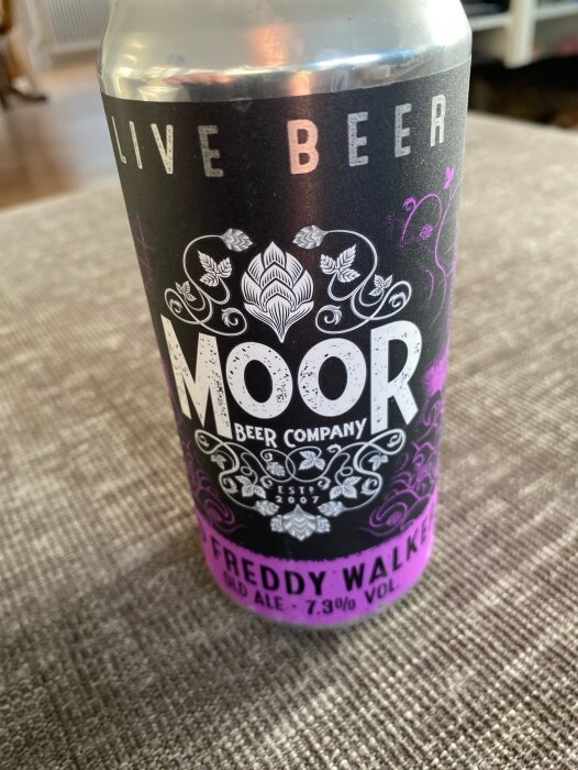 Burk av mörk ale från Moor Beer Company, Freddy Walker volym 7.3%, med beskrivande text och dekor.