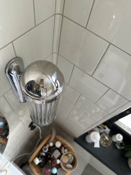 En vägglampa med spegeleffekt och ribbat glas i ett badrum, hur byter man glödlampan?