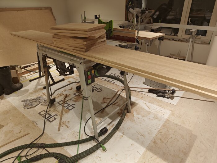 En verkstadsbild med hyvelbord, askträplankor och snickeriverktyg, indikerar snickeriarbete i process.