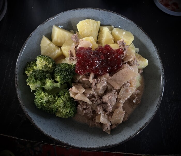 En tallrik med kålmaja bestående av köttfärs, vitkål, kokt potatis, broccoli och en klick lingonsylt.