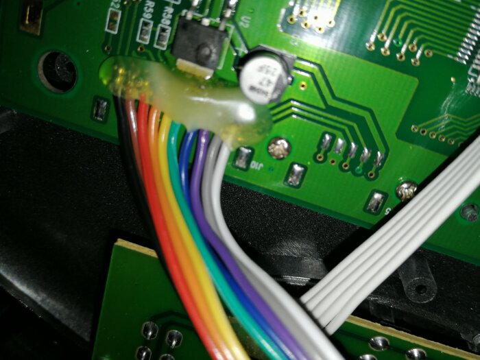 Flerfärgade kablar anslutna till ett kretskort, svårigheter att identifiera pluskabeln.