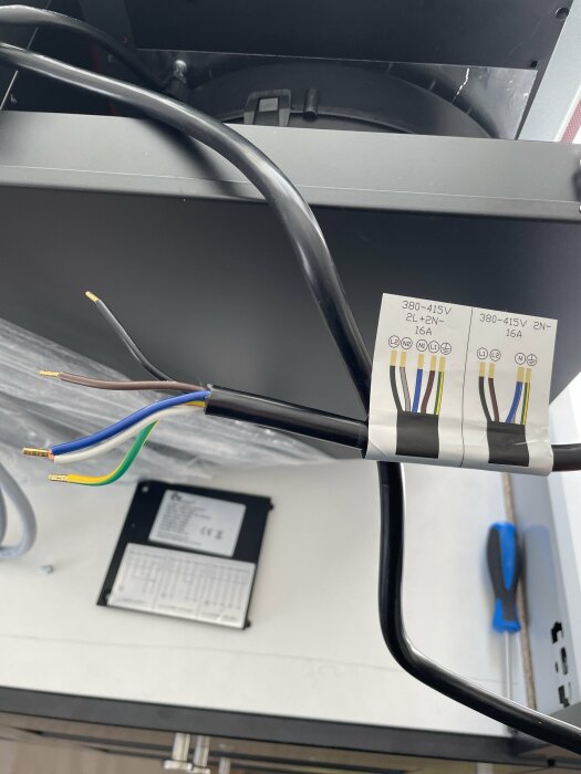 Elkabel med avskalade ändar redo för installation intill en etikett om elektrisk koppling.