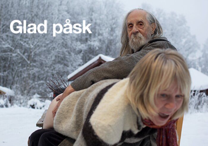 Två personer i vinterskog med texten "Glad påsk", man bär grenbukett, kvinna i förgrunden.