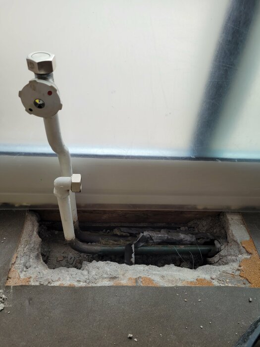 Öppet golv där radiatorrör syns efter borttagning av radiator, inga t-kopplingar synliga, slutet av slingan.